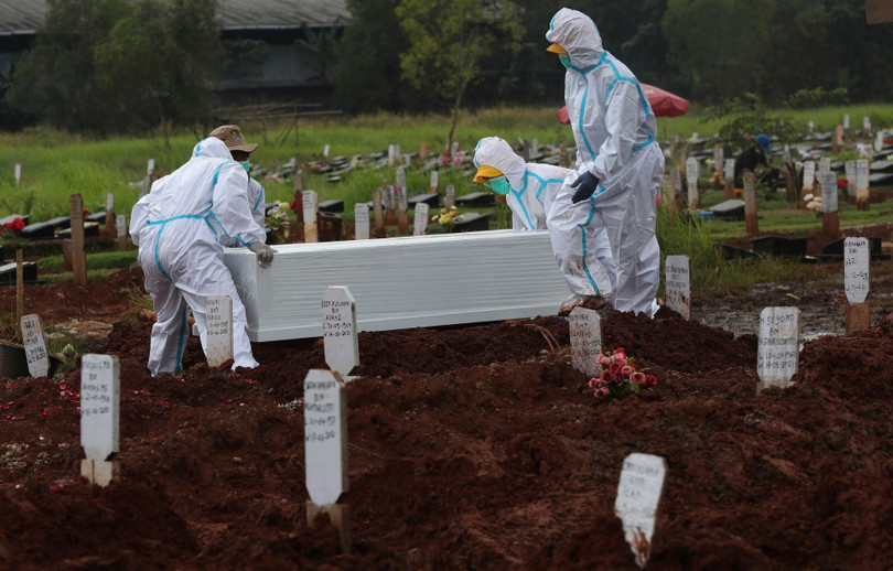 Ngày 17/6, tại Bekasi, Tây Java, các công nhân nghĩa trang đang chôn cất những chiếc quan tài trong khu đặc biệt của Nghĩa trang Padulanam, nơi vừa được mở thêm để giải quyết tình trạng số người chết gia tăng đột biến. (AP)