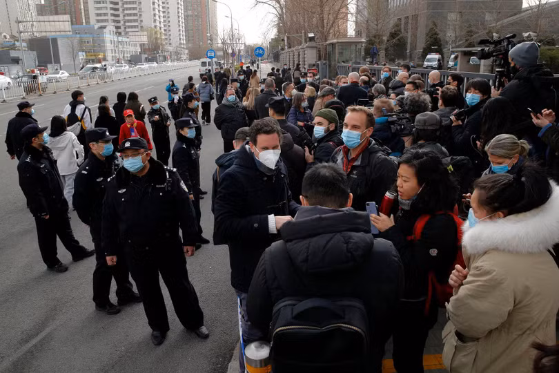 Các nhà ngoại giao , giới báo chí và nhân viên an ninh Trung Quốc bên ngoài phòng xử án (Ảnh: Reuters).