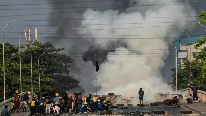 Người biểu tình đụng độ cảnh sát ở cầu thị trấn Hlaing (Ảnh: Reuters).