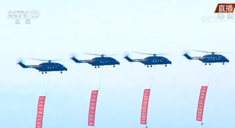 Các trực thăng Z-18 mang theo các khẩu hiệu chào mừng bay qua quảng trường (Ảnh: CCTV). Các trực thăng Z-18 mang theo các khẩu hiệu chào mừng bay qua quảng trường (Ảnh: CCTV).