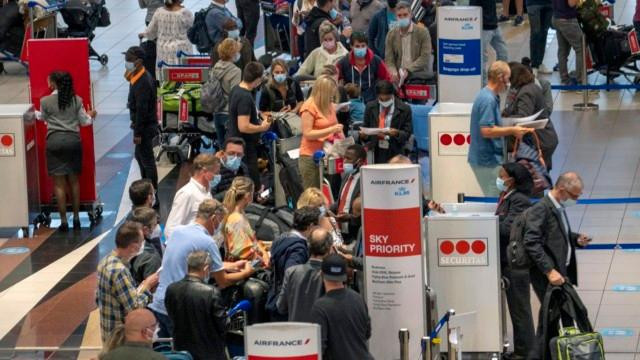 Du khách đổ xô ra sân bay về nước khi nhiều quốc gia thông báo lệnh cấm nhập cảnh với Nam Phi. Ảnh: AP Du khách đổ xô ra sân bay về nước khi nhiều quốc gia thông báo lệnh cấm nhập cảnh với Nam Phi. Ảnh: AP