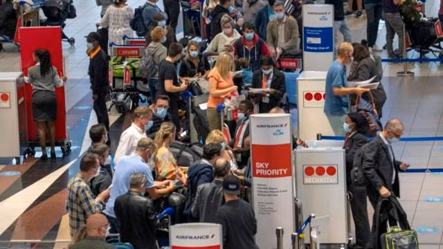 Du khách đổ xô ra sân bay về nước khi nhiều quốc gia thông báo lệnh cấm nhập cảnh với Nam Phi. Ảnh: AP