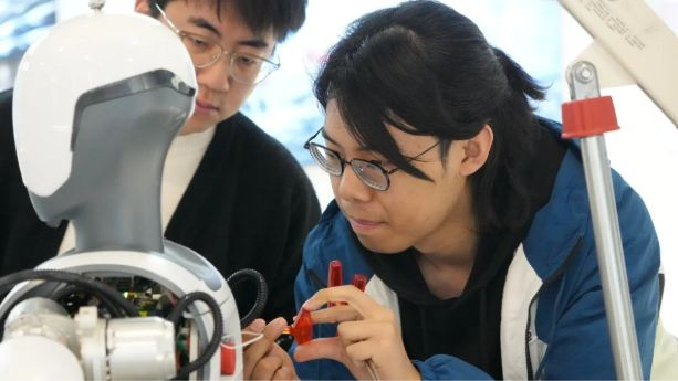 Các công nhân tại Deep Robotics có trụ sở tại Hàng Châu đang gỡ lỗi một robot hình người vào ngày 28 tháng 2. Ảnh: Xinhua.