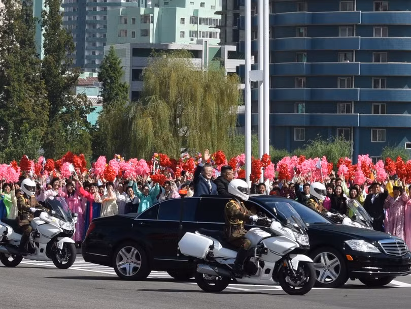 Hai nhà lãnh đạo đi trên xe mui trần vẫy chào những người dân ra đón suốt gần 1 giờ đồng hồ
