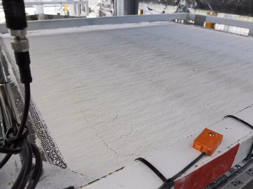 Một lớp các hạt nhỏ vật liệu có nguồn gốc từ đá vôi (vôi bột) trên khay thu giữ carbon. Ảnh E&amp;T