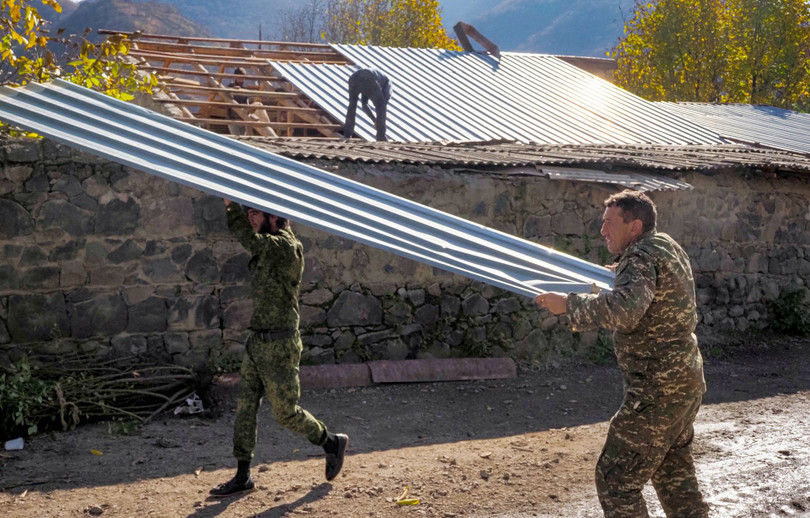 Người Armenia dỡ các tấm tôn mang đi trước khi nổi lửa đốt ngôi nhà của mình (Ảnh: AP).