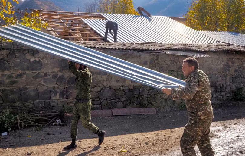 Người Armenia dỡ các tấm tôn mang đi trước khi nổi lửa đốt ngôi nhà của mình (Ảnh: AP). Người Armenia dỡ các tấm tôn mang đi trước khi nổi lửa đốt ngôi nhà của mình (Ảnh: AP).