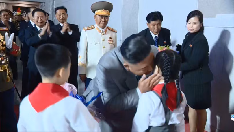 Tại cuộc diễu binh hôm 10/10, bà Hyon Song-wol nhận hoa của các thiếu nhi tặng ông Kim Jong-un (Ảnh: Reuters).