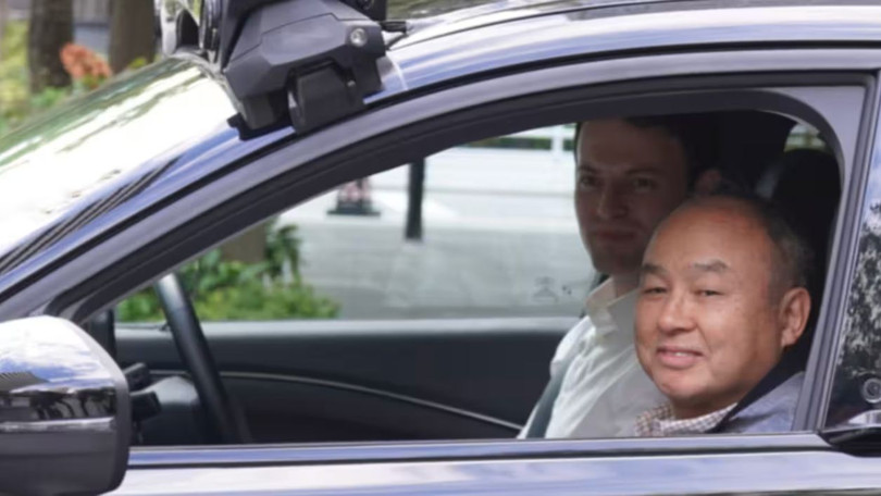 Chủ tịch kiêm Tổng giám đốc điều hành Tập đoàn SoftBank Masayoshi Son ngồi cạnh Tổng giám đốc điều hành Wayve Alex Kendall trên chiếc xe tự lái ở Tokyo. Ảnh: Nikkei Asia.