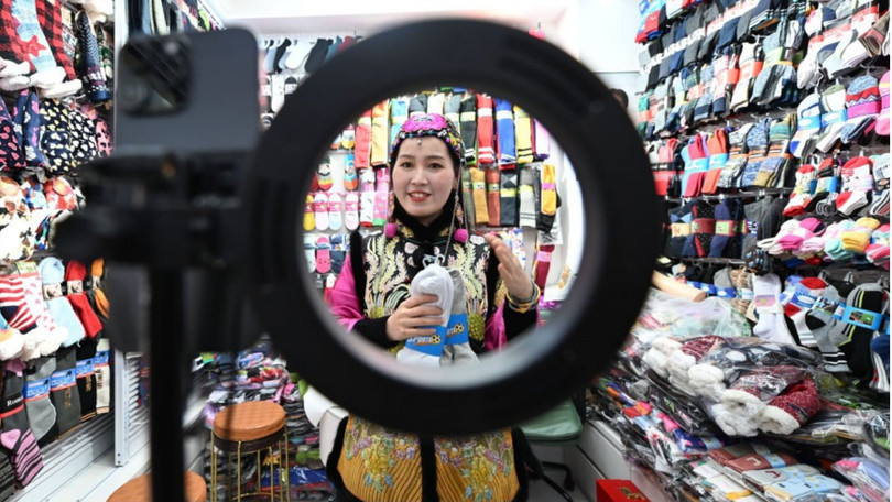 Chủ một cửa hàng bán tất ở Thành phố Thương mại Quốc tế Nghĩa Ô sử dụng AI để tạo video giới thiệu sản phẩm. Ảnh: China News Service.