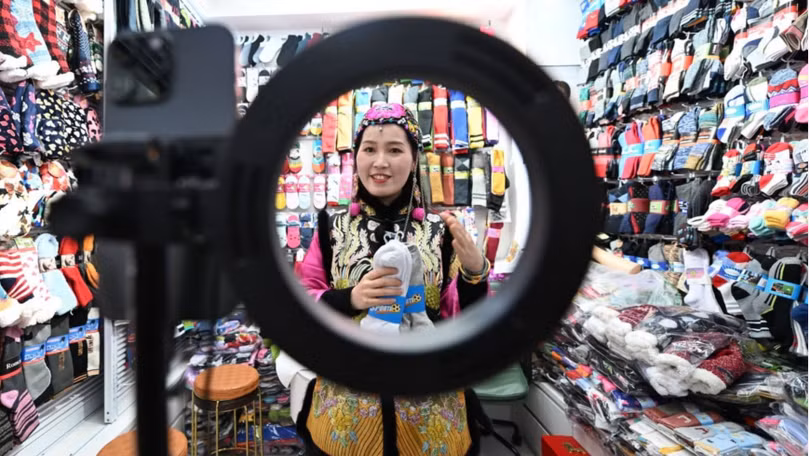 Chủ một cửa hàng bán tất ở Thành phố Thương mại Quốc tế Nghĩa Ô sử dụng AI để tạo video giới thiệu sản phẩm. Ảnh: China News Service.