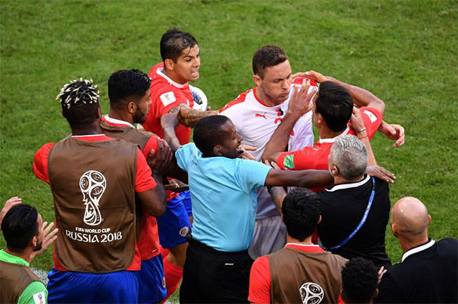 Tiền vệ người Serbia, Nemanja Matic, bị các cầu thủ Costa Rica cản lại sau một cuộc đụng độ với một trong những huấn luyện viên của họ.