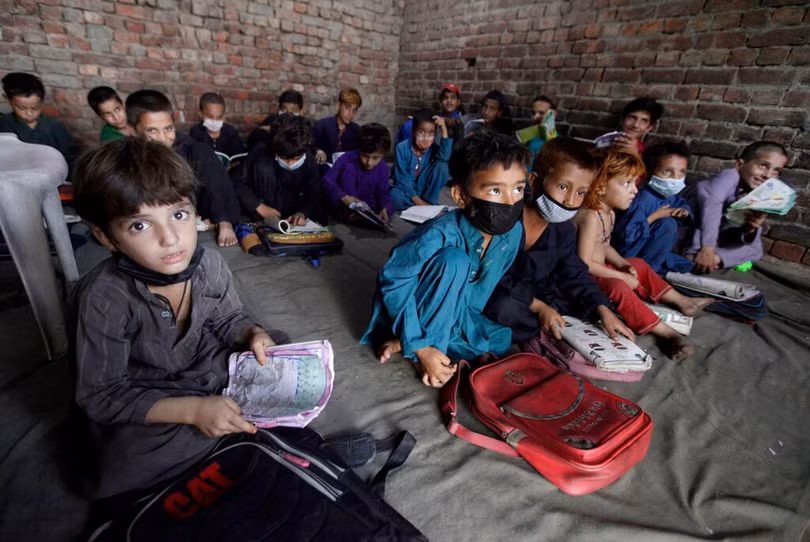 Trẻ em Afghanistan theo bố mẹ chạy sang Pakistan tị nạn (Ảnh Reuters).