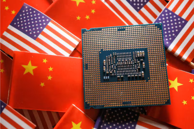 Một con chip bán dẫn được trưng bày giữa các lá cờ của Trung Quốc và Mỹ (Ảnh: Reuters)