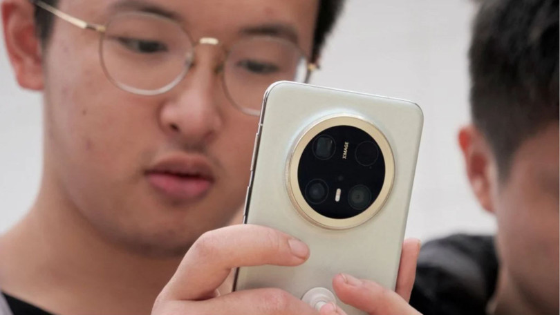 Một du khách đang xem dòng điện thoại thông minh Mate 70 mới nhất của Huawei tại một cửa hàng ở Bắc Kinh. Ảnh: Reuters.