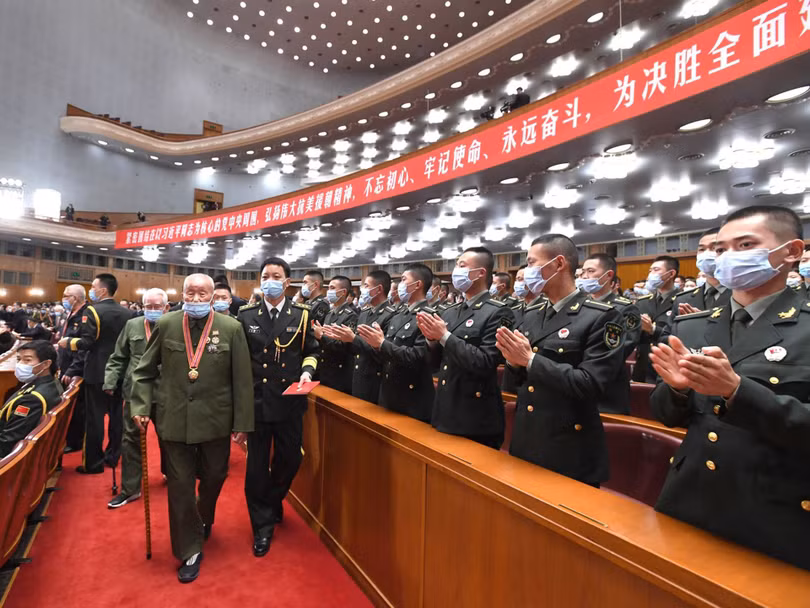 Quang cảnh cuộc mít tinh, mọi người hoan nghênh khi các cựu Chí nguyện quân tiến vào hội trường (Ảnh: Tân Hoa xã).