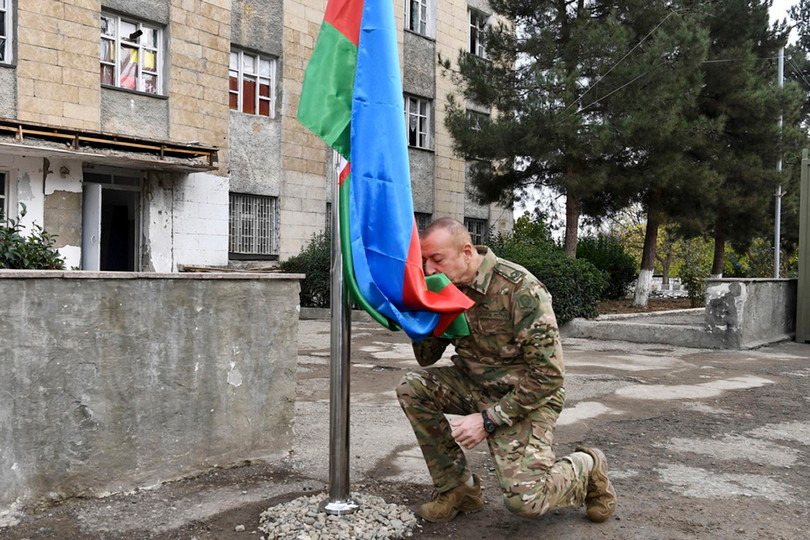 Tổng thống Azerbaijan Aliyev hôn quốc kỳ trước khi kéo lên tại thủ phủ Stepanakert của Nagorno-Karabakh (Ảnh: AP).