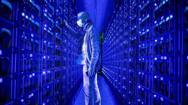 Một nhân viên đeo khẩu trang bảo vệ kiểm tra các hệ thống đào tiền điện tử Ethereum và Zilliqa tại trang trại tiền điện tử Evobits ở Cluj-Napoca, Romania.