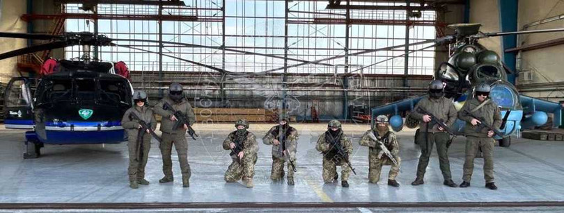 Binh sĩ lực lượng tác chiến đặc biệt của GUR bên cạnh máy bay UH-60A Black Hawk (trái) và Mi-24 Hind (Ảnh: GUR).