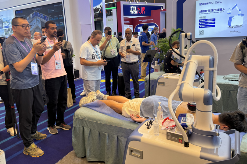 Khách quốc tế xếp hàng chờ trải nghiệm trên robot trị liệu. Ảnh: Nfnews.