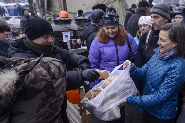 Trợ lý Bộ trưởng Ngoại giao Mỹ Nuland phân phát bánh cho những người biểu tình trong cuộc bạo loạn trên Quảng trường Maidan ở Kiev năm 2014 (Ảnh: Lenta)