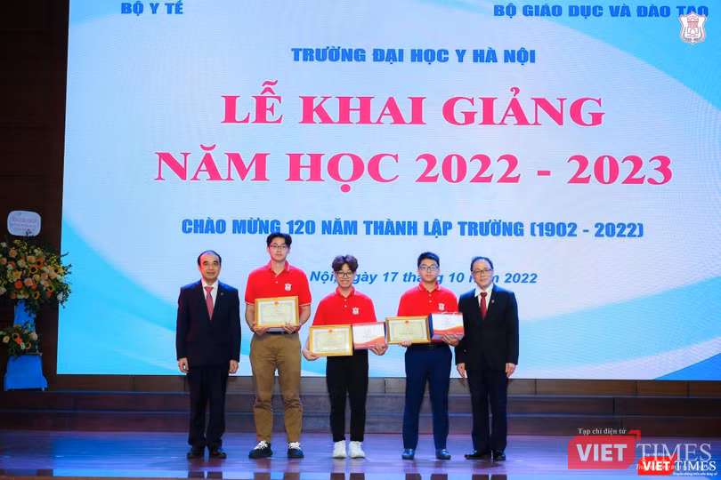 GS.TS. Tạ Thành Văn và GS.TS. Nguyễn Hữu Tú trao Giấy khen và phần thưởng cho 3 sinh viên xuất sắc: Thủ khoa năm 2022 Nguyễn Đăng Khải và 2 sinh viên giành giải quốc tế là Võ Tiến Thành và Phan Xuân Hành.