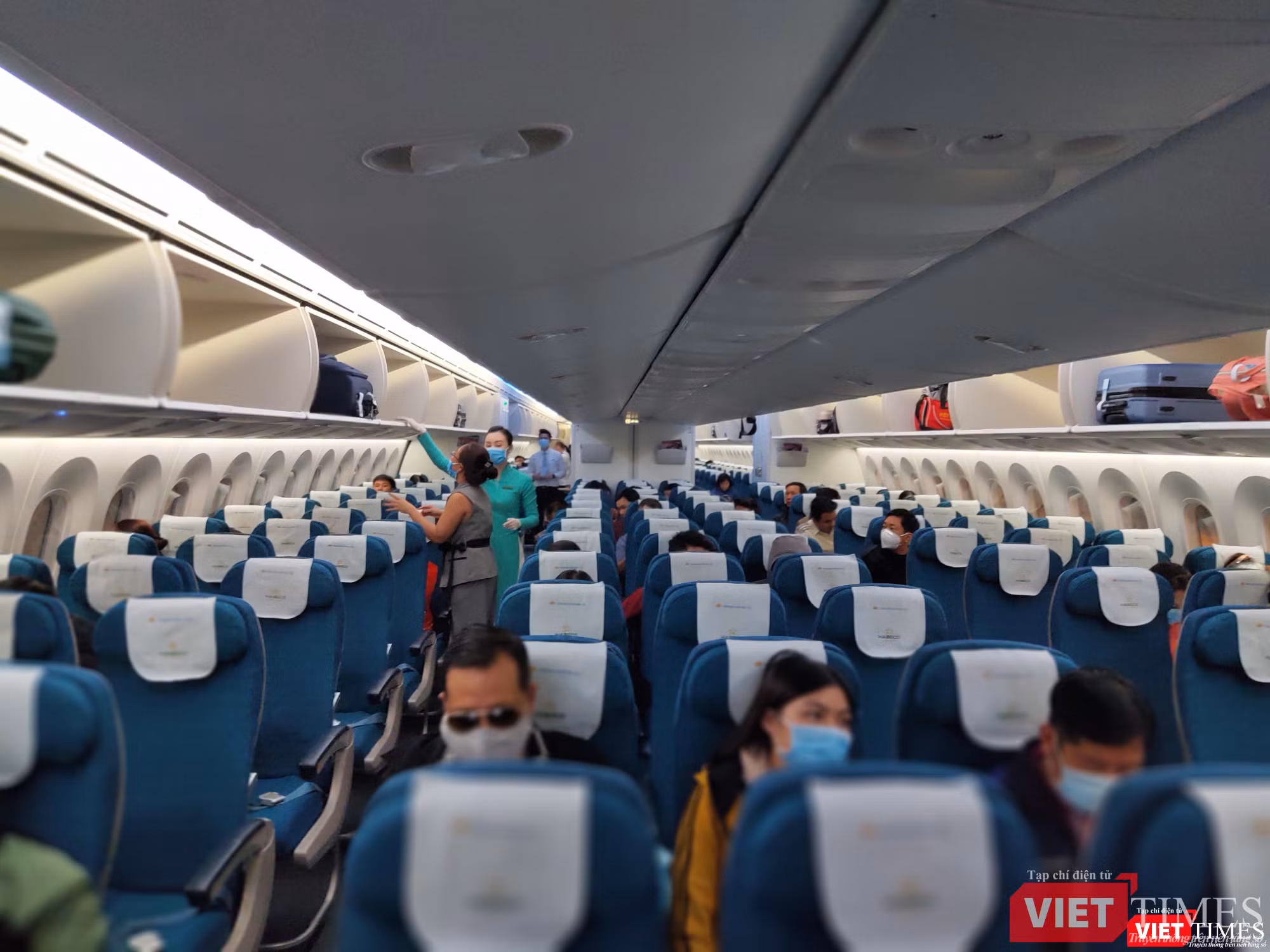 Tiếp viên và hành khách đều đeo khẩu trang trên máy bay