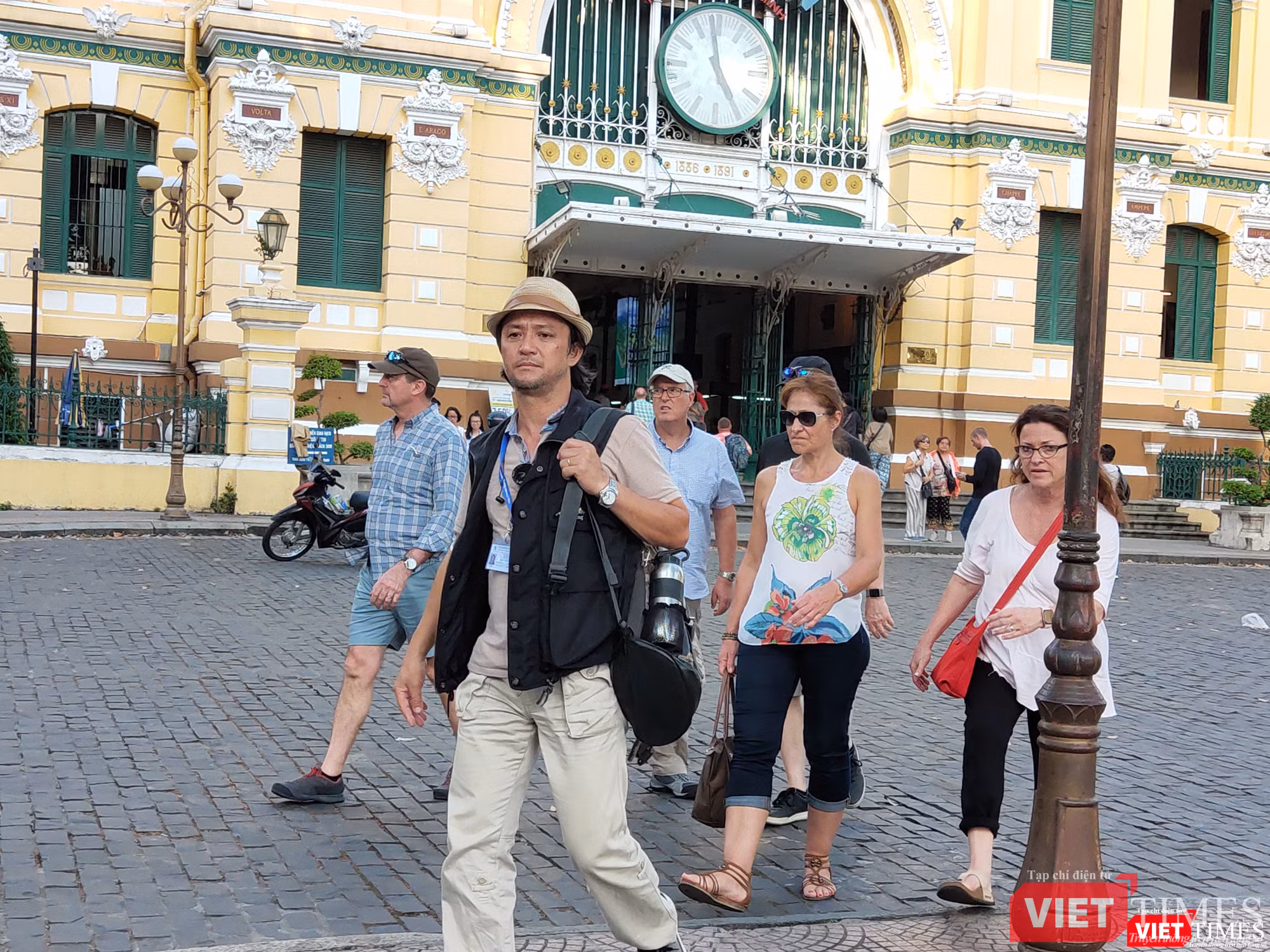 Vị HDV (đội mũ), dẫn đầu đoàn, không đeo khẩu trang trong suốt quá trình đi với du khách Vị HDV (đội mũ), dẫn đầu đoàn khách, không đeo khẩu trang trong suốt quá trình làm việc