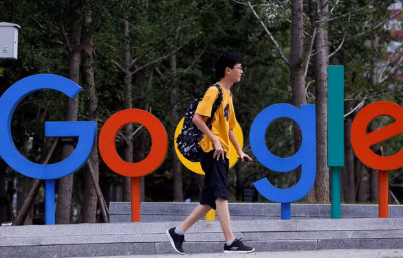 Một thanh niên đi qua khu vực đặt logo Google bên ngoài văn phòng của họ tại thủ đô Bắc Kinh, Trung Quốc - Ảnh: REUTERS