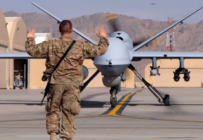 Một lính không quân Mỹ đang hướng dẫn chiếc máy bay không người lái MQ-9 Reaper thuộc Lực lượng Không quân Mỹ vào đường băng tại Căn cứ không quân Kandahar, Afghanistan (Ảnh Reuters) Một lính không quân Mỹ đang hướng dẫn chiếc máy bay không người lái MQ-9 Reaper thuộc Lực lượng Không quân Mỹ vào đường băng tại Căn cứ không quân Kandahar, Afghanistan (Ảnh Reuters)