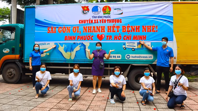 Phó Bí thư Tỉnh Đoàn Lê Thị Hồng Phấn (bìa trái) và các thành viên của nhóm Bất động sản Mỹ Hiệp bên cạnh “Chuyến xe yêu thương” trước giờ khởi hành, cùng gửi trao lời chúc Sài Gòn mau vượt qua bão COVID-19