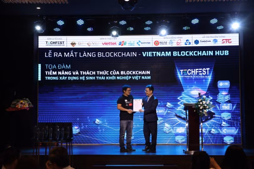 Đại diện Cục phát triển thị trường và doanh nghiệp - Bộ Khoa học và Công nghệ (NATEC) - trao quyết định cho Trưởng làng Blockchain