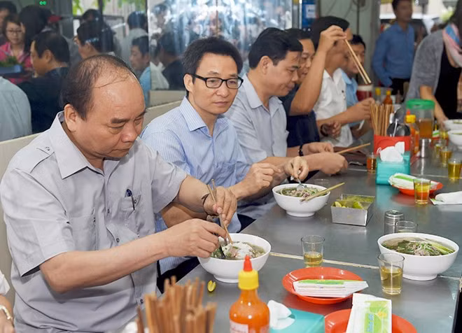 Thủ tướng và đoàn kiểm tra dừng chân, dùng điểm tâm tại một quán ăn đường phố thuộc phường Tân Thành, TPHCM. Ảnh: VGP/Quang Hiếu. 
