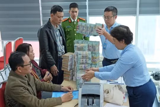 Người dân được nhân viên ngân hàng hỗ trợ nhận tiền bồi thường, hỗ trợ, tái định cư do phải di dời để thực hiện dự án làm quảng trường, công viên phía Đông hồ Hoàn Kiếm. Ảnh: Trọng Phú