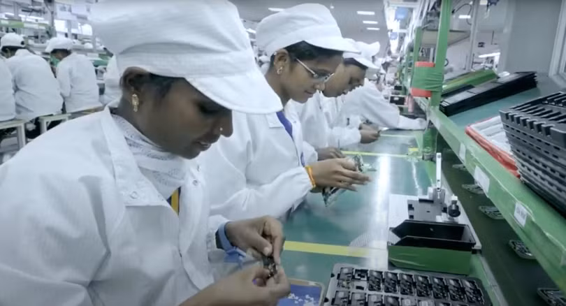 Các công nhân làm việc tại một dây chuyền lắp ráp bên trong khu phức hợp sản xuất điện thoại thông minh của Tập đoàn Công nghệ Foxconn ở Sri City, quận Tirupati thuộc bang Andhra Pradesh, phía đông nam Ấn Độ. Ảnh: YouTube