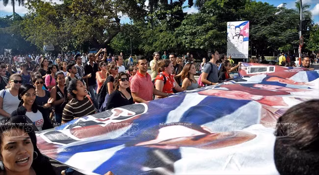 Người dân Cuba tuần hành tại Thủ đô Havana chào đón 3 chiến sĩ tình báo Cuba được Chính phủ Mỹ trả tự do cùng ngày với việc Cuba và Mỹ công bố quyết định bình thường hóa quan hệ ngoại giao. Ảnh: AFP/TTXVN 