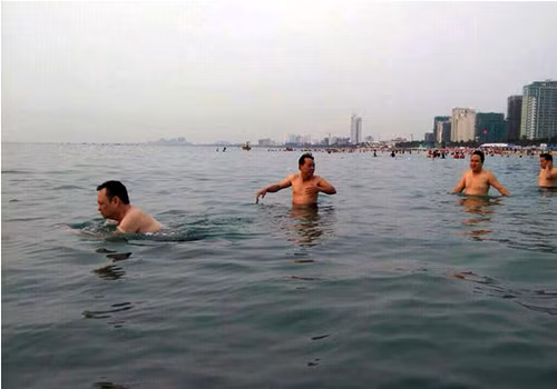 Ông Nguyễn Điểu (ngoài cùng bên trái) cùng nhiều lãnh đạo ngành tài nguyên môi trường Đà Nẵng đi tắm biển Phạm Văn Đồng trong sáng 30/4.