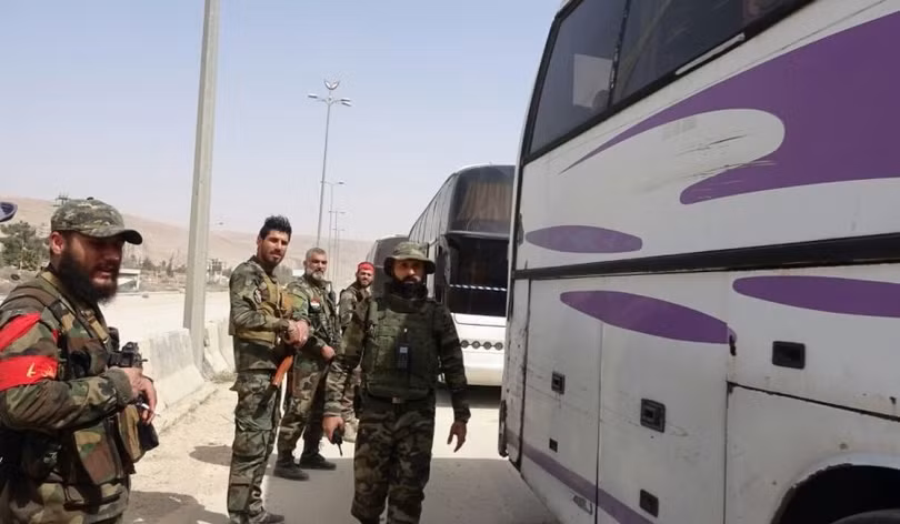 Quân đội Syria đang canh gác cac chuyến xe buýt rời Đông Ghouta - ảnh video mnh họa