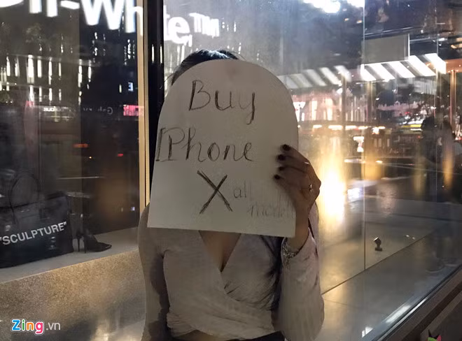 Một phụ nữ đến từ TP.HCM cầm tờ giấy rao mua lại iPhone X tất cả các phiên bản ngay trước Apple Store Singapore. iPhone X khan hiem: Su doi tra cua Apple hinh anh 2