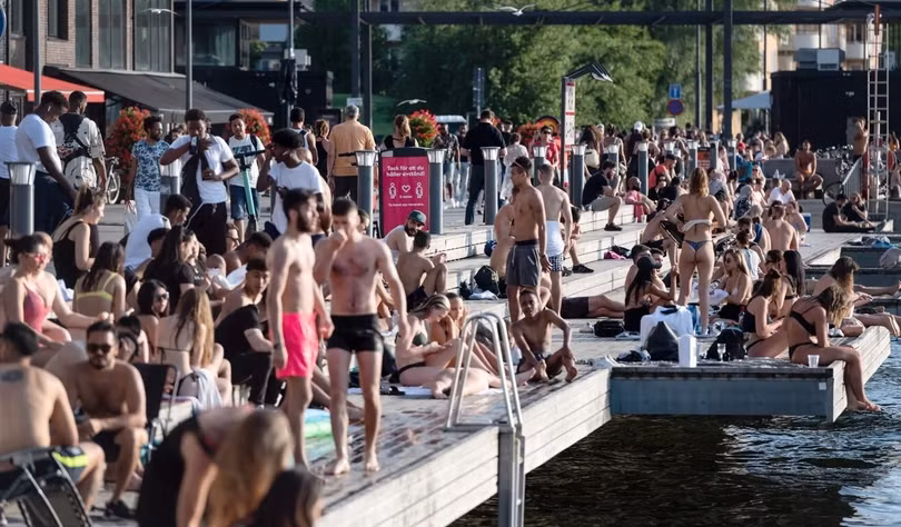 Người dân thủ đô Stockholm không đeo khẩu trang, tập trung đông người bên một bờ sông để tránh nóng (Ảnh: EPA) Người dân thủ đô Stockholm không đeo khẩu trang, tập trung đông người bên một bờ sông để tránh nóng (Ảnh: EPA)