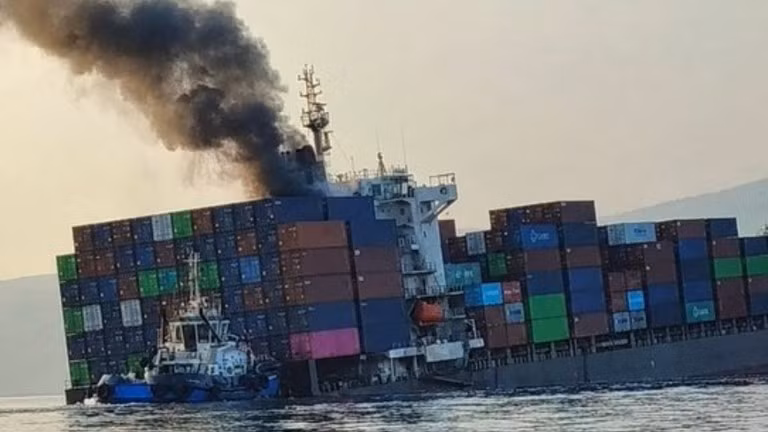 Khói bốc lên từ con tàu container GFS Pride đang nghiêng sau khi nó va phải thủy lôi ở eo biển Hormuz vào ngày 14/10. Ảnh: RT.