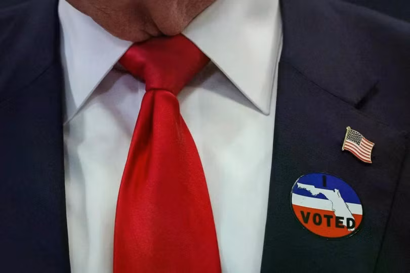Tổng thống Mỹ Donald Trump đeo nhãn dán "Tôi đã bỏ phiếu" sau khi bỏ phiếu sớm tại Văn phòng Giám sát Bầu cử Quận Palm Beach ở Florida hôm 24/10. Ảnh: AFP.