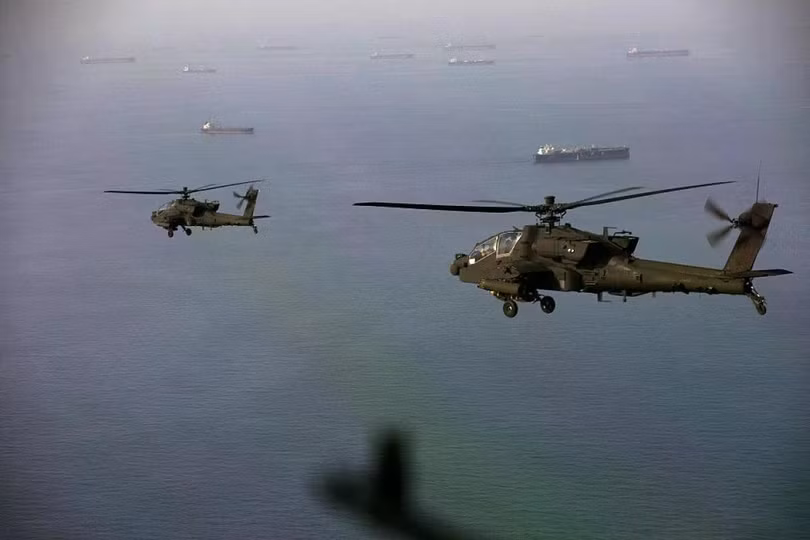 Máy bay trực thăng AH-64 Apache bay phía trên eo biển Hormuz trong một cuộc tuần tra vào ngày 17/4. Ảnh: AFP.