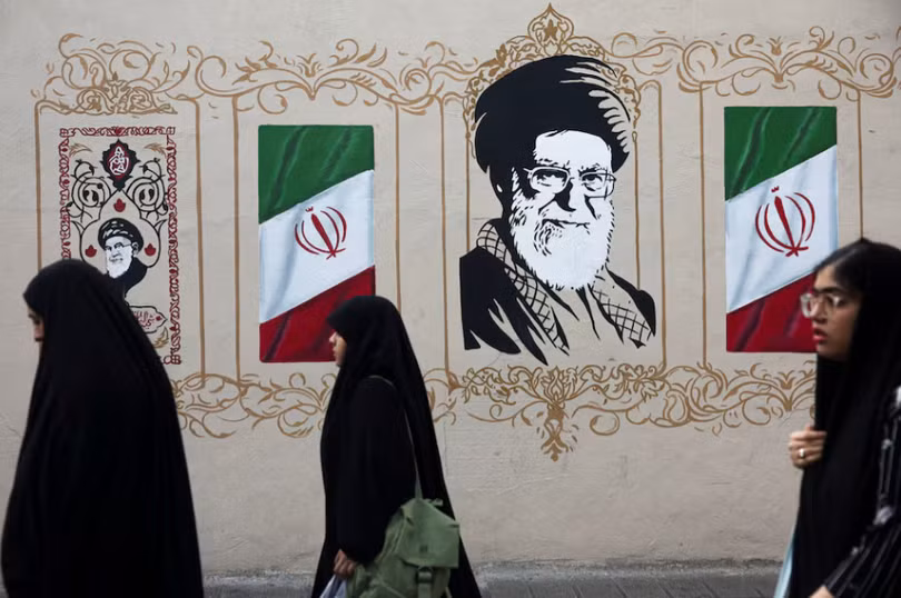Người dân đi bộ ngang qua bức tranh tường mô tả cố lãnh đạo tối cao của Iran, Ayatollah Ali Khamenei, trên một con phố ở Tehran, Iran, ngày 13/8. Ảnh: Reuters.