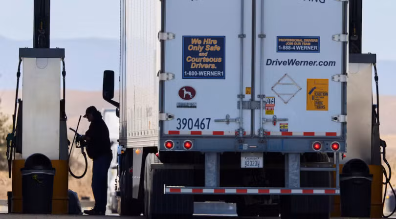 Một tài xế vận hành máy bơm nhiên liệu diesel tại trạm dừng xe tải ở Dunnigan, California, Mỹ, ngày 28/9. Ảnh: Reuters.