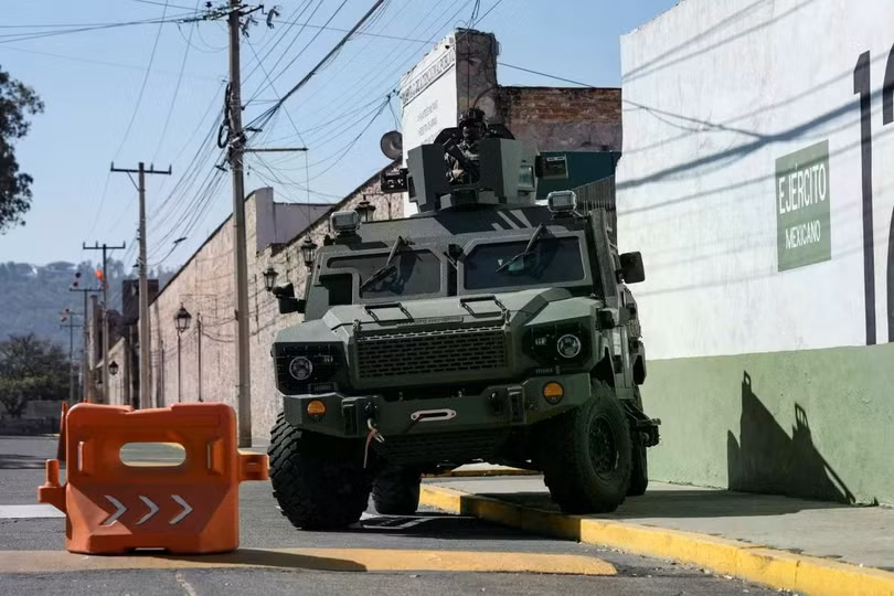 Một binh sĩ đứng trên nóc xe bọc thép bên ngoài một cơ sở quân sự ở Morelia, Mexico. Ảnh: Reuters.