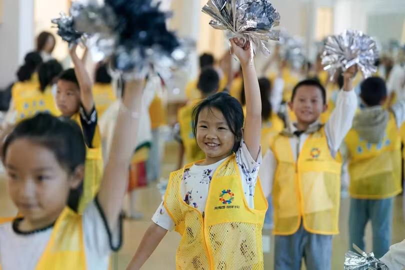 Các em nhỏ tham gia chương trình giữ trẻ đang học một bài cổ vũ tại trung tâm hoạt động ở thành phố Triệu Thông, tỉnh Vân Nam, Trung Quốc. Triệu Thông đã triển khai chương trình giữ trẻ miễn phí cho các bậc phụ huynh đi làm cần người trông trẻ trong giờ làm việc. Ảnh: Tân Hoa Xã