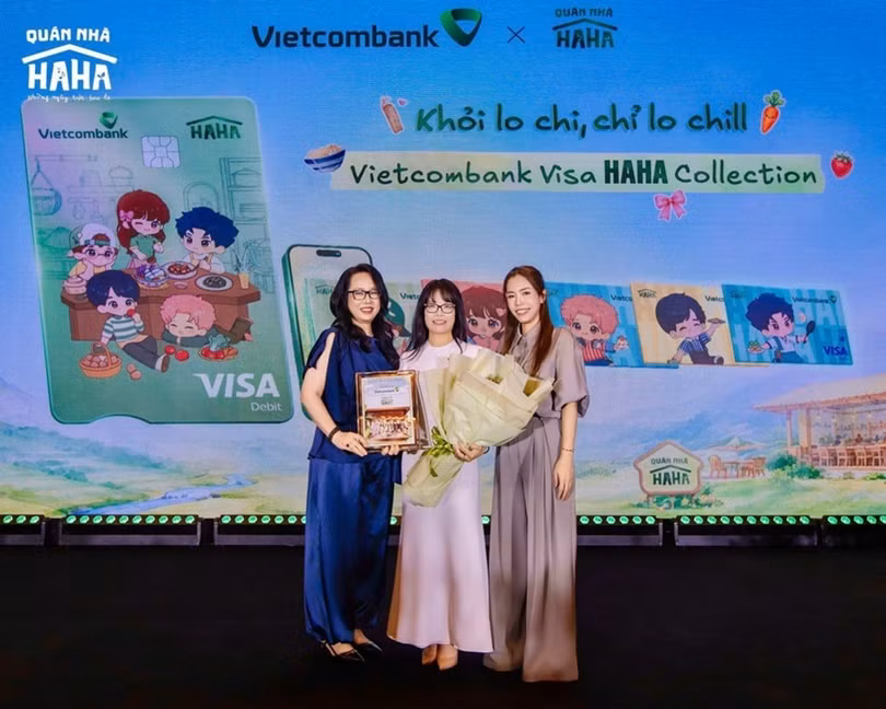 Bà Đoàn Hồng Nhung - Thành viên BĐH, Giám đốc Khối Bán lẻ Vietcombank (ở giữa) đại diện ngân hàng nhận hoa và biểu trưng từ đơn vị sản xuất tại họp báo ra mắt Quán Nhà Haha. Ảnh: Vietcombank cung cấp.
