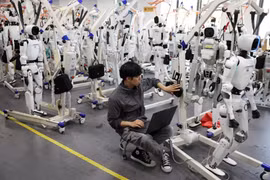 Một kỹ sư đang làm việc giữa các robot hình người Tiangong Omni tại khu vực nghiên cứu và thử nghiệm của Trung tâm Đổi mới Robot Hình người Bắc Kinh, hay còn gọi là X-Humanoid, ở Bắc Kinh, Trung Quốc, ngày 4/9. Ảnh: Reuters.