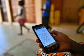 Một người lao động tự do Kenya đang ngồi xem điện thoại. Quốc gia này là một trong những nơi tập trung lực lượng lao động trong nền kinh tế bóng đêm AI. Ảnh: AFP.